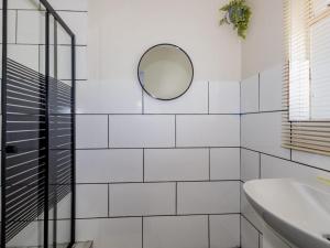 a white bathroom with a mirror and a sink at Olive House in Brackenfell +37 photos