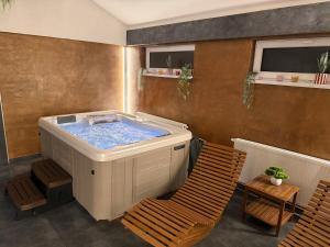 a jacuzzi tub in a room with two chairs at Bungalovy CLASSIC & Wellness Podhájska - Adults Only in Podhájska +22 photos