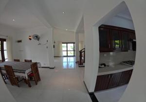 a kitchen and dining room with a table and chairs at Shade Villa in Galle