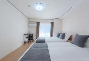a hotel room with two beds and a desk at サムティ扇町 in Osaka