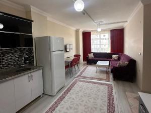 a kitchen with a refrigerator and a living room at Ada Mevan Otel in Ipekyolu