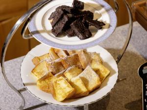 a plate of waffles and a bowl of chocolate cake at KOKO HOTEL Nagoya Marunouchi in Nagoya