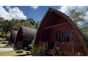a couple of small wooden homes in a yard at Senara Resort Ciwidey in Baruhtunggul