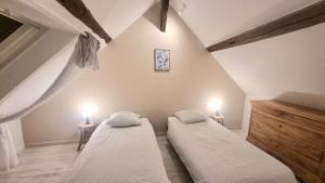 two beds in a room with two lights on the wall at La Parenthèse in Amboise