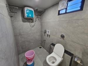 a bathroom with a toilet and a tv on the wall at Gajraj Hotel in Vadodara