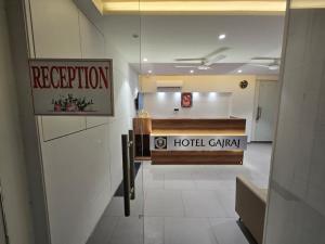 a hotel lobby with a hotel carasy sign on the wall at Gajraj Hotel in Vadodara