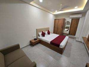a hotel room with a bed and a couch at Gajraj Hotel in Vadodara +4 photos