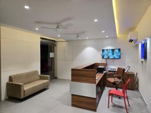 an office with a couch and a desk and a chair at Gajraj Hotel in Vadodara