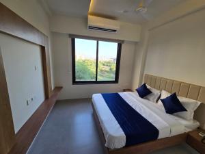 a bedroom with a large bed with a window at Gajraj Hotel in Vadodara