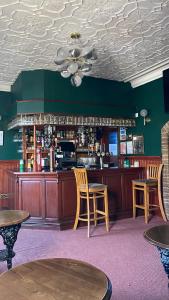 a bar with two chairs and a counter with alcohol at Victoria Inn in Alston
