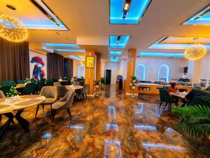 a restaurant with tables and chairs and blue lights at Chilonzor Hotel in Tashkent