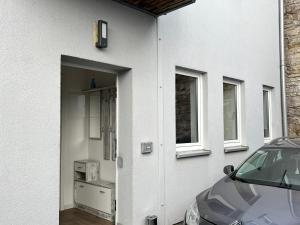 a white house with a car parked next to it at Apartment CentrumMitte Anger in Erfurt