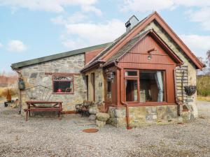 a log cabin with a picnic table in front of it at Islay Cottage in Kincraig
