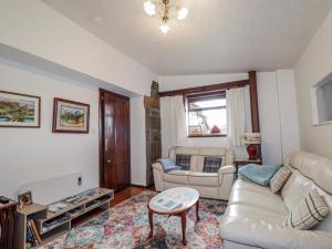 a living room with a couch and a table at Islay Cottage in Kincraig