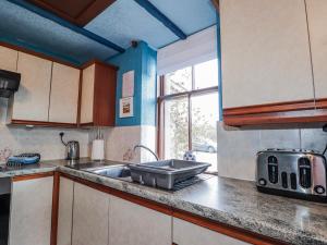 a kitchen with a sink and a counter top at Islay Cottage in Kincraig +27 photos