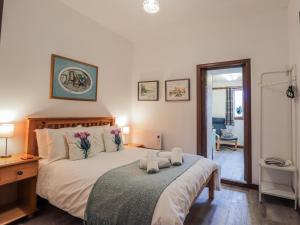a bedroom with a bed with two stuffed animals on it at Islay Cottage in Kincraig