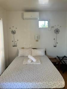 a bedroom with a bed with a white bedspread at Little Miami Beach Resort in Anda