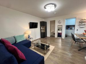 a living room with a blue couch and a table at Apartment CentrumMitte Anger in Erfurt