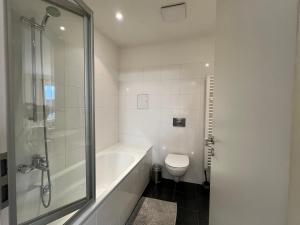 a white bathroom with a tub and a toilet at Apartment CentrumMitte Anger in Erfurt +14 photos