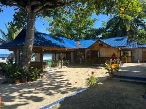 a building with a blue roof on the beach at Little Miami Beach Resort in Anda