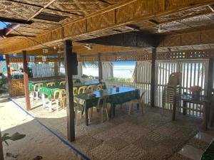 a restaurant with a table and chairs on a balcony at Little Miami Beach Resort in Anda