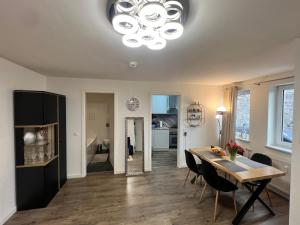 a dining room and living room with a table and chairs at Apartment CentrumMitte Anger in Erfurt