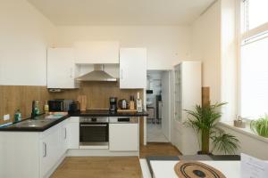 a kitchen with white cabinets and a counter top at Studio Apartment nahe Lüneburg in Bienenbüttel