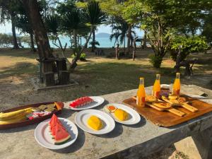 a table with plates of food and bottles of beer at Angthong Beach Resort in Koh Phaluai
