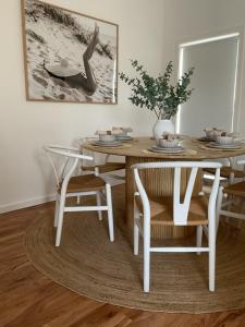 a dining room table and chairs with a vase on it at Saltwater at Warilla Beach in Lake Illawarra