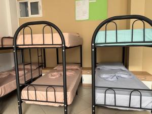 a room with three bunk beds in a dorm room at Exeas Hostel in Vlorë