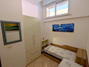 a small bedroom with a bed and a mirror at Grottammare mon amour Kira in Grottammare