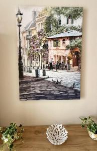 a painting of a street lamp and pigeons on a city street at The Alley Suites in Gudja