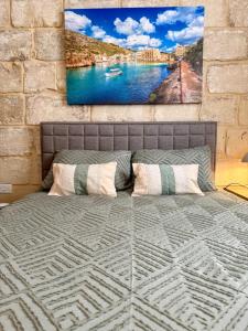 a bedroom with a bed with a painting on the wall at The Alley Suites in Gudja