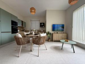 a living room with a table and a dining room at The Alley Suites in Gudja