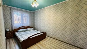 a small bedroom with a bed and a wall at Vinnytsia, Vyshenka in Vinnytsya