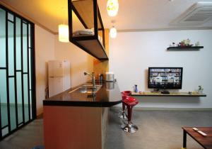 a kitchen with a counter and a tv in a room at Gyeongju Eowoolim Pension in Gyeongju