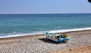 a blue boat sitting on a beach next to the ocean at Gyeongju Eowoolim Pension in Gyeongju