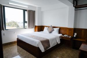 a bedroom with a large bed with a large window at Khách Sạn Hạo Nhiên in Buon Ma Thuot