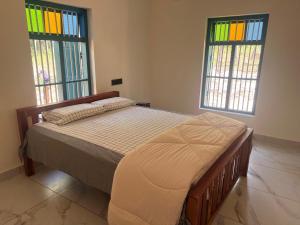 a bed in a bedroom with stained glass windows at Kabani By Kallar in Trivandrum