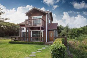 a large house with a balcony on a lawn at Sumang Pension in Seogwipo +33 photos