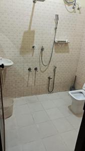 a bathroom with a shower and a toilet at Mermaid Manor in Varkala