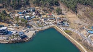 an aerial view of a resort next to a lake at Fortune Rising Sun Hill Pension in Pocheon