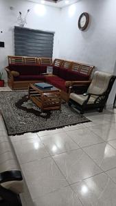 a living room with couches and a coffee table at Mermaid Manor in Varkala