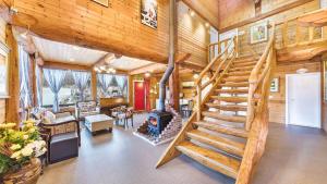 a living room with a staircase in a log cabin at Muju Moonriver Pension in Wŏnsamgŏri