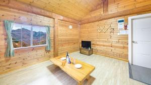 a wooden room with a table and a television at Muju Moonriver Pension in Wŏnsamgŏri