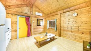 a living room with a table in a log cabin at Muju Moonriver Pension in Wŏnsamgŏri +14 photos