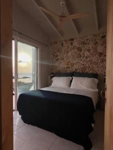a bedroom with a large bed with a stone wall at Binilua in Binibeca