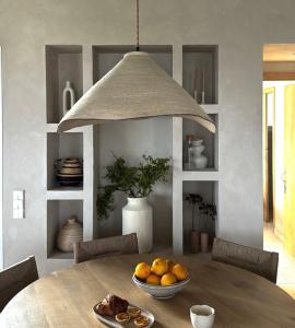 a dining room with a table with a bowl of oranges at Binilua in Binibeca