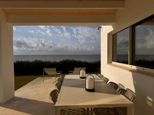 a patio with a table and chairs and the ocean at Binilua in Binibeca