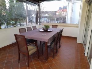 a table and chairs in a room with a large window at Vila Vasi- Μodern maisonette view Meteora in Kastraki